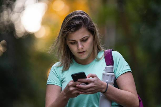 istock Sportswoman using smartphone in the park 1328047568