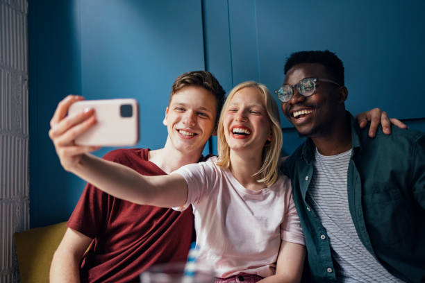 istock Three Cheerful Friends Taking Selfie in a Coffee Shop 1328049292