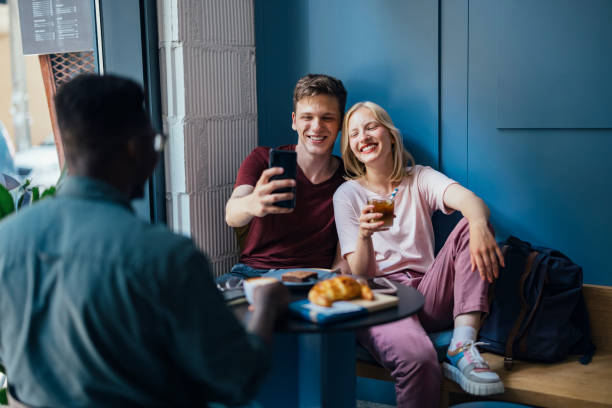 istock Group of Friends Having Fun While Making Selfie on Mobile Phone in a Cafe 1328049396