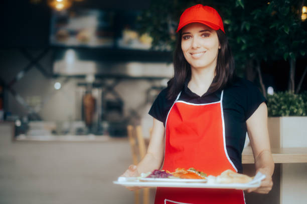 istock Happy Waitress Holding Food Tray Working in a Restaurant 1328064140