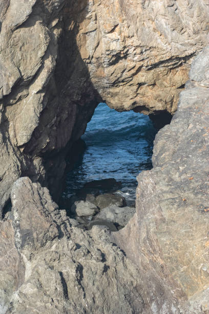 istock Peek of the Ocean through the Rock 1328068792