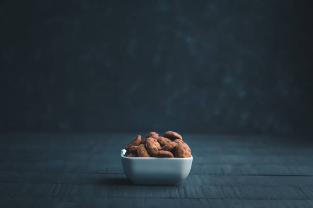 Ceramic container filled with chocolate chip cookies on a minimalist dark background stock photo