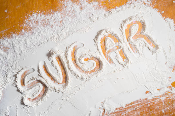 Word sugar written with flour. Health problems due to poor nutrition stock photo