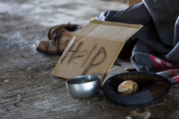 hombre sin hogar y hambriento que duerme en un edificio abandonado o en la calle con letreros para obtener ayuda y necesita comida y dinero - begging fotografías e imágenes de stock