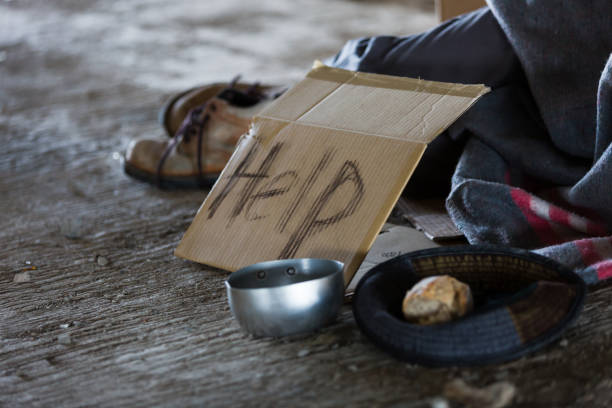 bezdomny i głodny mężczyzna śpiący w opuszczonym budynku lub na ulicy z szyldem o pomoc i potrzebuje jedzenia i pieniędzy - tramp zdjęcia i obrazy z banku zdjęć
