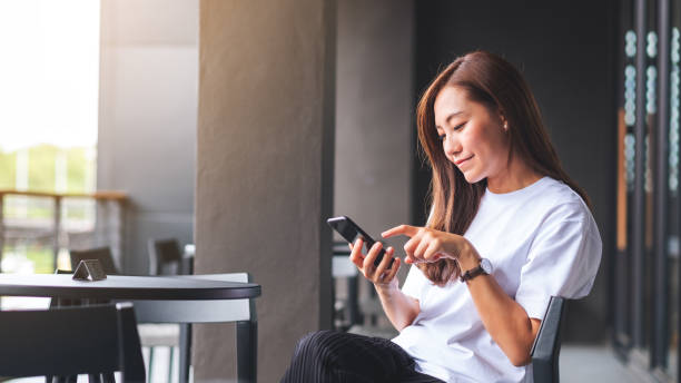 istock A beautiful young asian woman holding and using mobile phone 1328081802