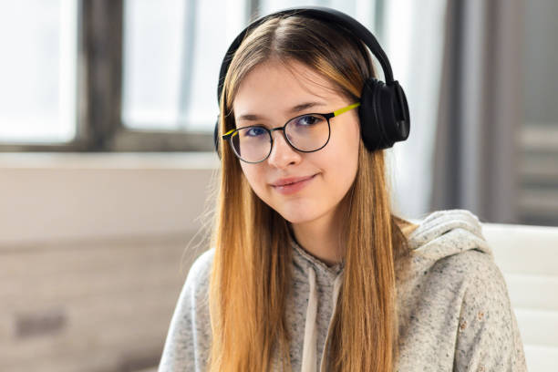 Distance learning, portrait of a beautiful girl schoolgirl in glasses and headphones looking at the camera, online education Distance learning, portrait of a beautiful girl schoolgirl in glasses and headphones looking at the camera, online education 12 13 years stock pictures, royalty-free photos & images