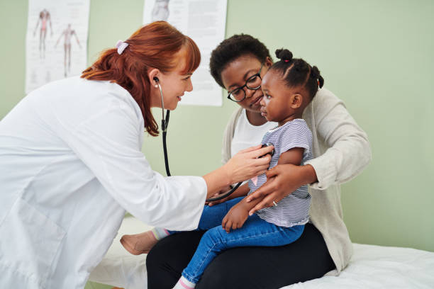 그녀의 어머니와 상담하는 동안 청진기와 사랑스러운 어린 소녀를 검사 의사의 샷 - pediatrician 뉴스 사진 이미지