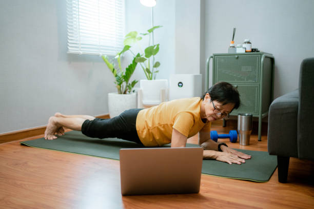 istock Asian senior woman watching video workout and training at home. 1328085565