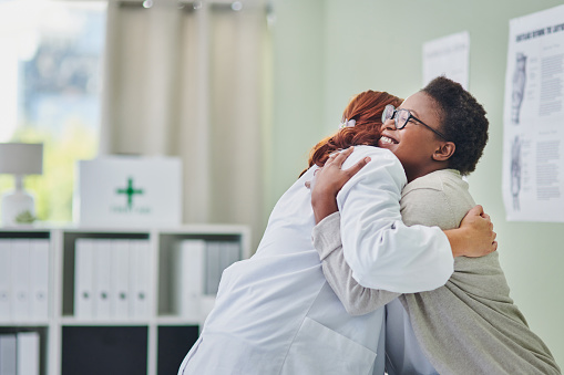 Disparo de una joven abrazando a su médico durante una consulta photo