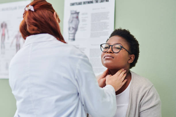 shot of a doctor examining a woman’s throat during a consultation - tonsill bildbanksfoton och bilder