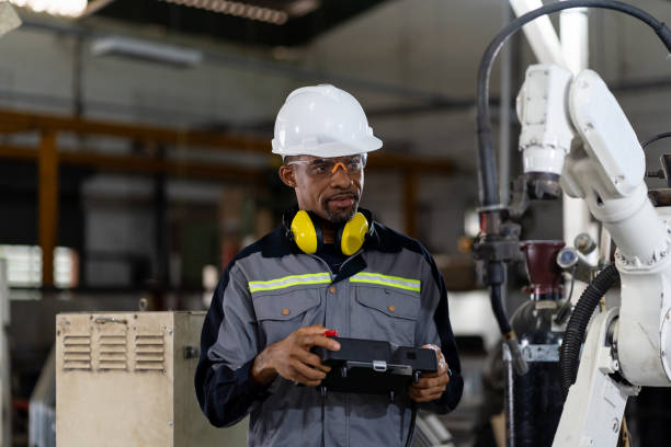 istock Male engineer holding robot controller for maintenance or repair automatic robotic machine in factory. Male technician worker working with control automatic robot arm system welding in the factory 1328087975