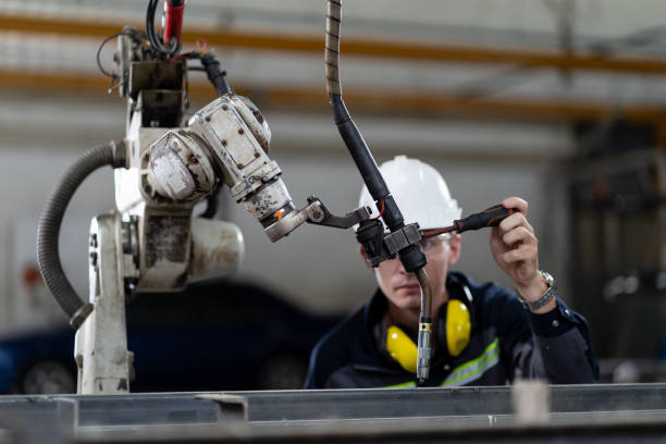 istock Male engineer worker maintenance automatic robotic arm machine in factory. Male technician worker working, checking, repair automatic robot hand machine with screwdriver in smart factory 1328087982