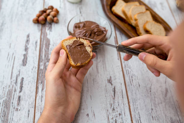 istock Slices of bread with chocolate cream nuts and knife. 1328088173