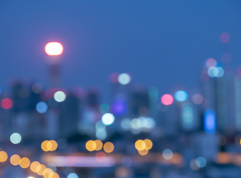 A softly focused cityscape at dusk, where the lights of the city create a colorful array of bokeh, capturing the tranquil mood of the evening.