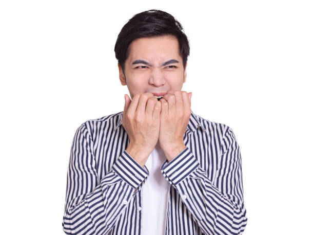 istock young man, showing  surprised or worried expression, and biting his fingers. Isolated on white background 1328091444