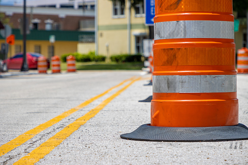An orange and silver construction barrier in the road during a road work project in a city.