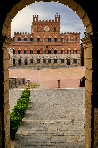 A suggestive view of Piazza del Campo, the medieval heart of Siena with its characteristic shell shape. In the background the majestic Palazzo Pubblico, built starting from 1290 for the seat of the Council of Nine and the executive power of the Sienese city. It is currently still the seat of the municipal government. Siena is one of the most beautiful Italian cities of art, in the heart of the Tuscan hills, in central Italy, famous for its immense artistic and historical heritage and for the Palio, where the seventeen districts of the city compete every year in Piazza del Campo in one of the oldest horse racing in the world. Since 1995 the historic center of Siena has been declared a World Heritage Site by UNESCO. Image in high definition format.