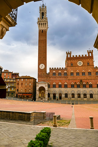 A suggestive view of Piazza del Campo, the medieval heart of Siena with its characteristic shell shape. In the background the beautiful Palazzo Pubblico (Town Hall) and the majestic Torre del Mangia (Mangia's Tower). Built starting in 1290, the Palazzo Pubblico was the seat of the Council of Nine and the executive power of the medieval city. Currently it is still the seat of the municipal government of the Tuscan city. Siena is one of the most beautiful Italian cities of art, in the heart of the Tuscan hills, in central Italy, famous for its immense artistic and historical heritage and for the Palio, where the seventeen districts of the city compete every year in Piazza del Campo in one of the oldest horse racing in the world. Since 1995 the historic center of Siena has been declared a World Heritage Site by UNESCO. Image in high definition format.