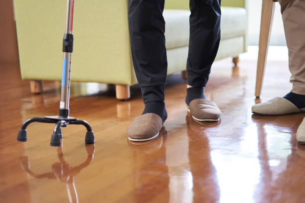 personas mayores y cuidadores caminando con un baste cuadrúpedo - atención residencial fotografías e imágenes de stock