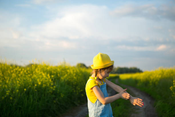 Girl kills mosquitoes on her hands and feet. Child slaps himself on body, scratches places of bites, protection from insect bites, repellent safe for children. Outdoor recreation, against allergies Girl in a field kills mosquitoes that bite her hands and feet. The child slaps himself on the body, protection from insect bites, repellent safe for children. Outdoor recreation, against allergies bug bite stock pictures, royalty-free photos & images