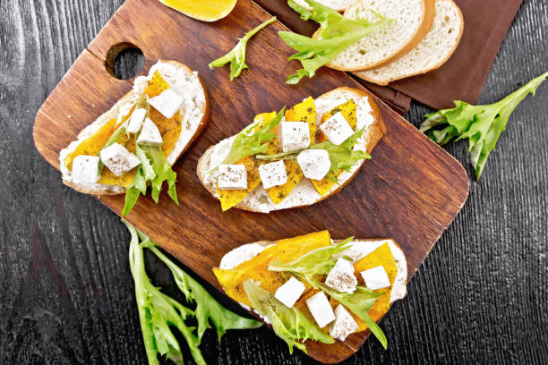 Bruschetta with pumpkin and arugula on wooden board top
