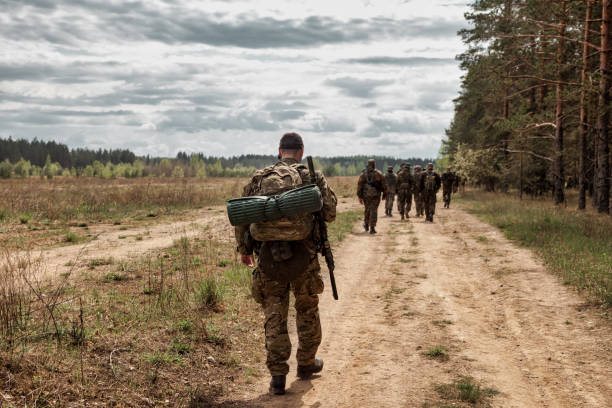 roup von soldaten in getarnten militäruniformen mit waffenkämmen durch das gebiet - commando stock-fotos und bilder