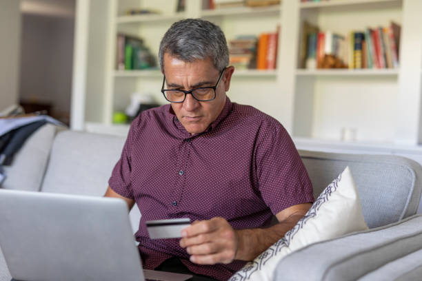 istock Mature Man Entering Credit Card Details into a Computer 1328103534
