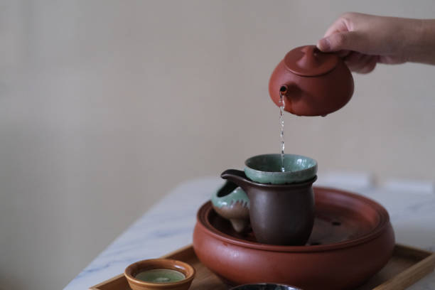 istock hand pouring tea water from traditional teapot 1328104842