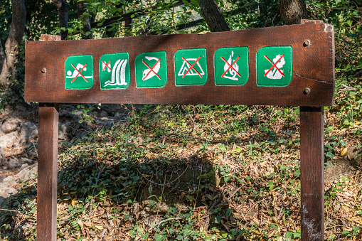 Information Sign in Krka National Park, Croatia, forbidding swimming, waterfall climbing, fishing, camping, fires or picking of flora