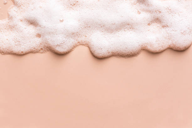 Face cleansing mousse sample Face cleansing mousse sample. White cleanser foam bubbles on nude background, copy space. Soap, shower gel, shampoo foam texture border. shampoo stock pictures, royalty-free photos & images