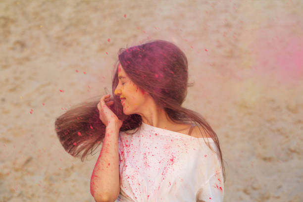 istock Gorgeous smiling brunette model with fluttering hair posing covered with Holi dry paint 1328120543