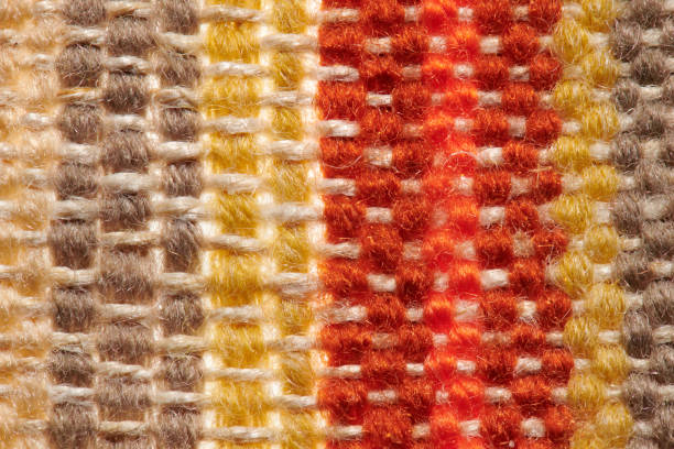 a small handmade rug or mat, woven from red and yellow wool threads, one object close-up