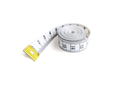 Close-up of a blue rolled up tape measure. Shallow depth of field, space for copy.