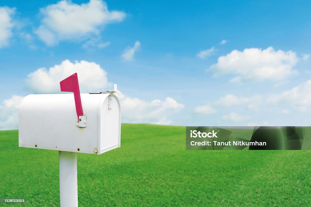 Vintage white post mailbox Vintage white post mailbox with blured outdoor green lawn grass and blue sky Mailbox Stock Photo