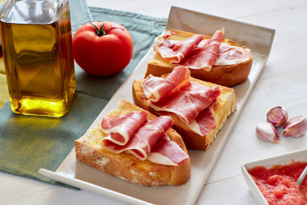 Mediterranean breakfast, spanish breakfast, toast whith olive oil, tomato and iberiann ham. stock photo