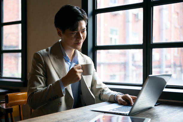 istock Asian businessman working with laptop at cafe 1328125944