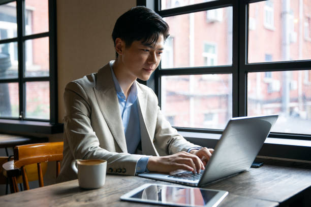 istock Asian businessman working with laptop at cafe 1328126416