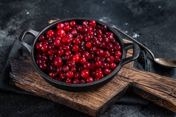 istock Red fresh Cranberry berry in a pan. Black background. Top view 1328127460