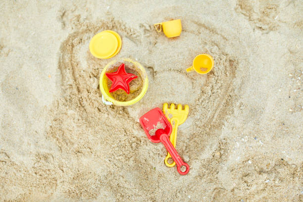 istock Top view, flat lay of scattered plastic beach toys on sand background 1328128321