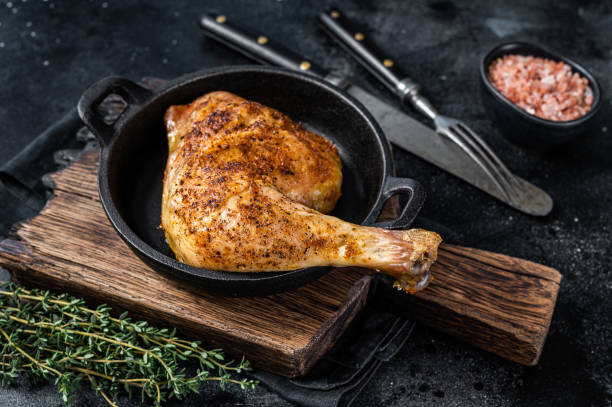 istock Fried bbq chicken leg in a pan. Black background. Top view 1328128537