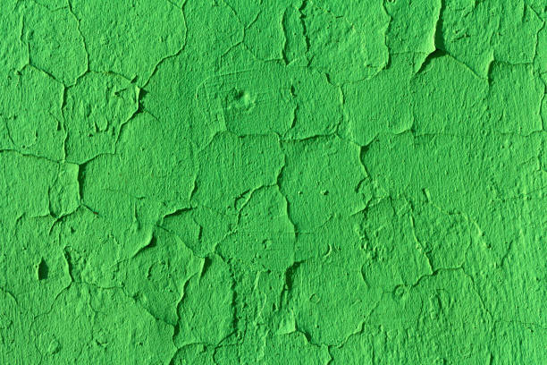 istock Old green wall with cracks on uneven rough plaster 1328129285