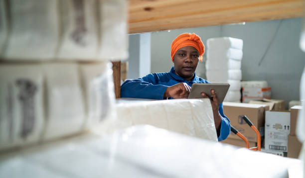 istock Afro female warehouse worker checking the shipment delivery on a digital tablet in distribution warehouse 1328131503