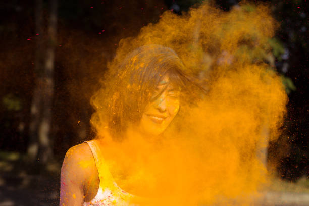 istock Closeup shot of happy young woman with exploding Holi paint around her 1328131695