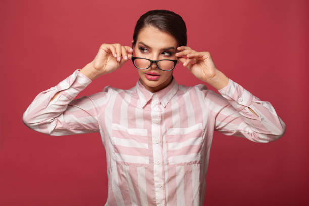 istock Smart woman in glasses on red background smiling 1328133766