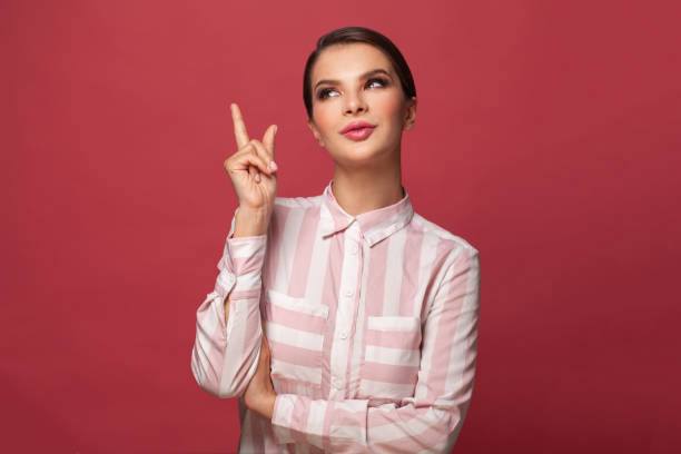 istock Cute brunette woman pointing up on red background banner 1328133772