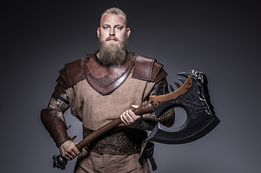 Weapon wielding viking warrior Odin god in studio shot