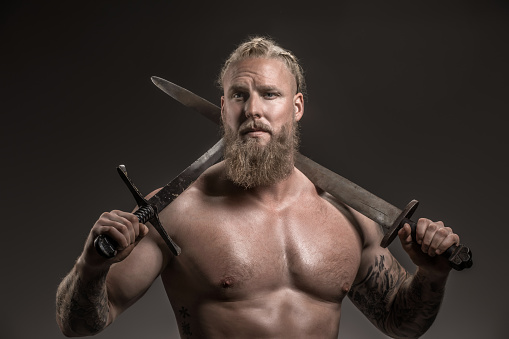 Weapon wielding viking warrior Odin god in studio shot