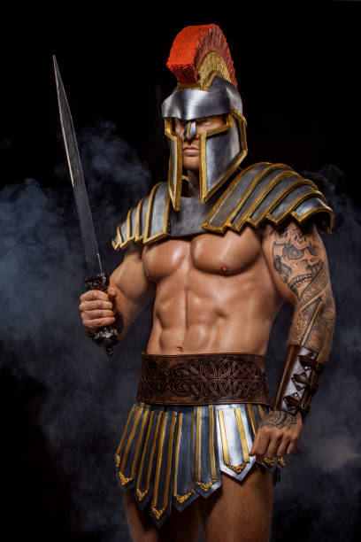 красивый мускулистый воин гладиатор держит оружие - gladiator sword warrior men стоковые фото и изображения