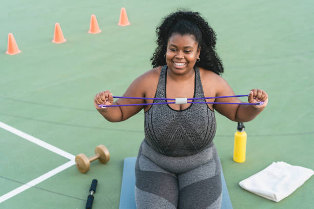 istock Curvy Afro woman doing workout  exercises session - Young African female having fun training outdoor - Sporty people lifestyle concept 1328141599